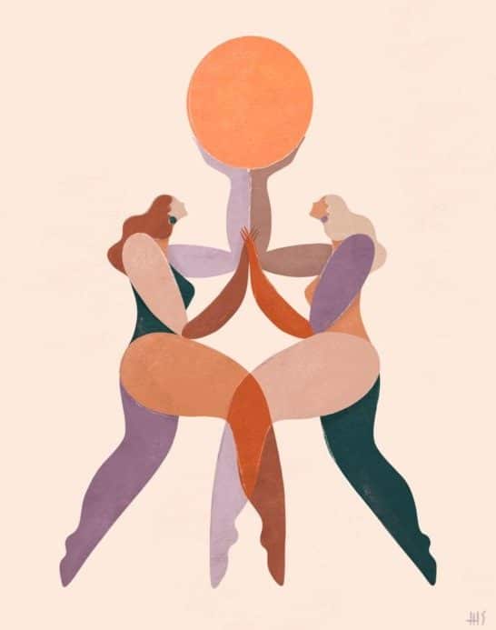 Two women holding up an orange ball